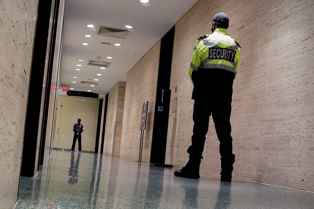 A,Low-angle,Shot,Of,Security,Guards,Patrolling,Inside,A,Commercial