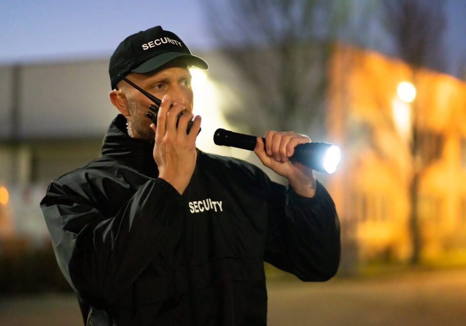 Security,Guard,Walking,Outdoors,With,Flashlight,At,Night