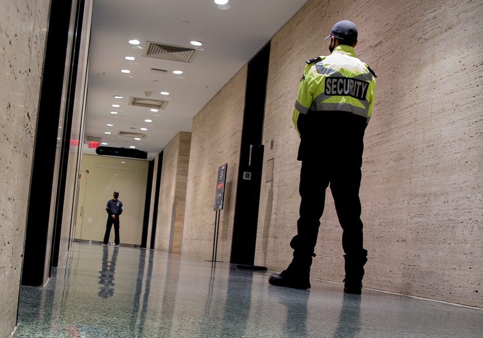 A,Low-angle,Shot,Of,Security,Guards,Patrolling,Inside,A,Commercial